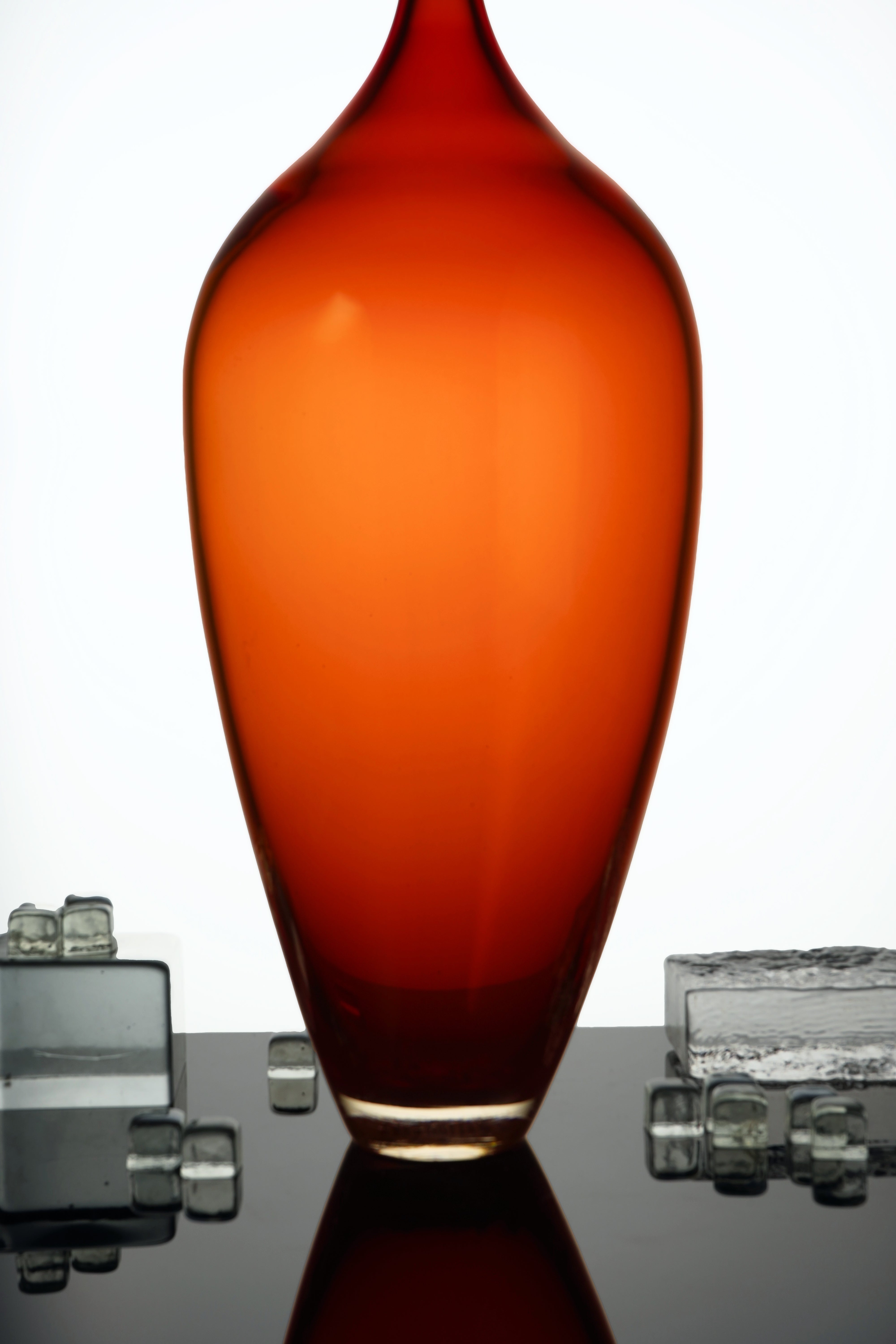 Edols & Elliott Red Glass Bottle Sculpture, handmade with exquisite craftsmanship. The vibrant red glass adds a pop of color and sophistication to any space.